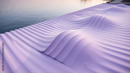 A purple wavy textured surface extending along the calm water edge at sunset