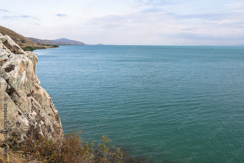 Fototapeta premium The sea is shown with clear water and a rocky shore