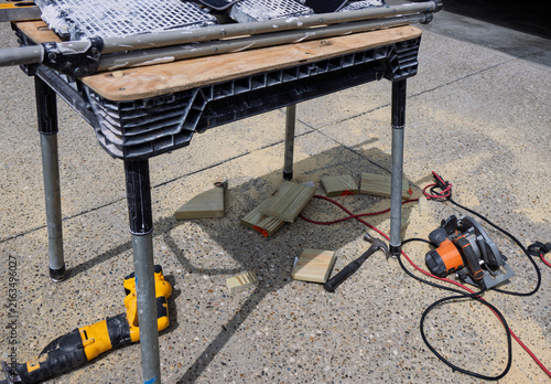 Folding workman's table with pipe legs and wooden planks.