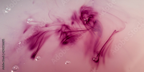 Fotografie a dark purple liquid that slowly dissolves, spreads, and swirls in a cloudy whit