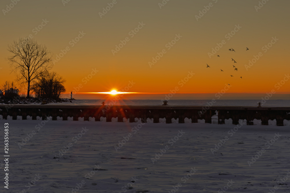 Obraz premium Winter sunrise over a frozen pier and Lake Erie at Port Dover, Ontario, Canada.
