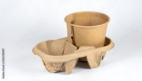 Close-up studio shot of a brown paper cup nested in a two-cup beverage holder. White background