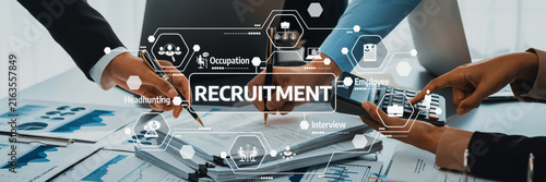 Professionals are collaborating in an office setting, focusing on recruitment strategies using persuasive data and graphs, showcasing teamwork and engagement with hiring practices. Amity