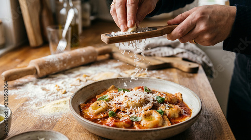 Person grating fresh cheese over delicious warm pasta bowl perfect for showcasing authentic italian cuisine and gourmet restaurant food styling