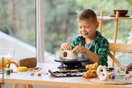 Obraz na plátně Child development and creative learning, young boy making pottery with clay at h