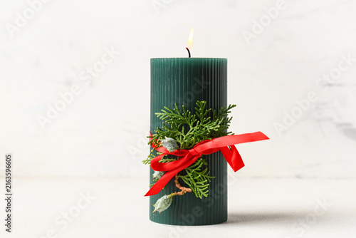 Foto Burning candle with Christmas branch on white table