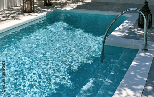 Crystal clear water in a tranquil outdoor swimming pool with steps