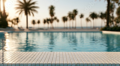 Sun-drenched pool tiles reflect palm trees and ocean at sunset
