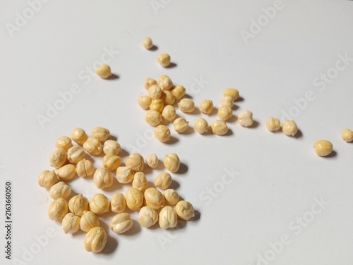Dried Chickpeas Scattered on White Background with Natural Shadows