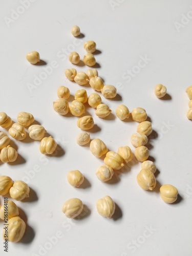 Dried Chickpeas Scattered on White Background with Natural Shadows