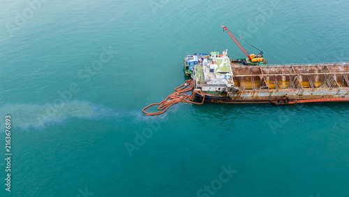 Quadro su tela Oil spill Industrial response ship deploying an orange containment boom to control and clean up a marine pollution spill in the open ocean, protecting the sea ecosystem from hazardous chemical waste