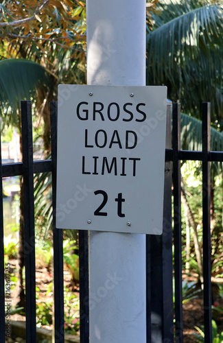 Konstfotografi A white rectangular sign mounted on a post stating GROSS LOAD LIMIT 2t against