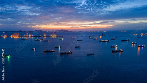 heavy oil tankers and LNG vessels anchored at a strategic maritime chokepoint during a golden sunset, emphasizing global energy crises and petroleum supply chain infrastructure.