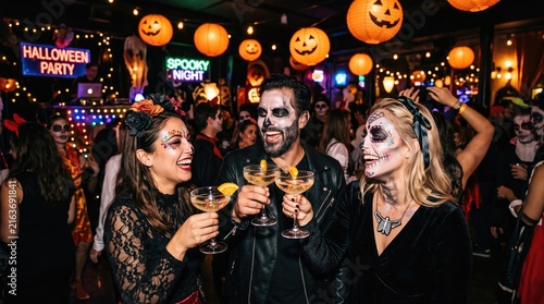 Energetic halloween party scene with costumed people and festive jack o lantern decorations