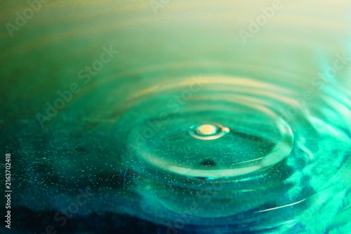 Concentric Water Ripples on Green and Gold Liquid Surface Close Up