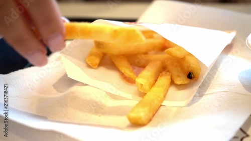 French fries fill package.
Hand takes potato.
Golden fries rest plate.
Fastfood creates appetizing scene.