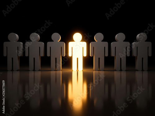 Illuminated figurines standing on a dark surface with reflections in a black background