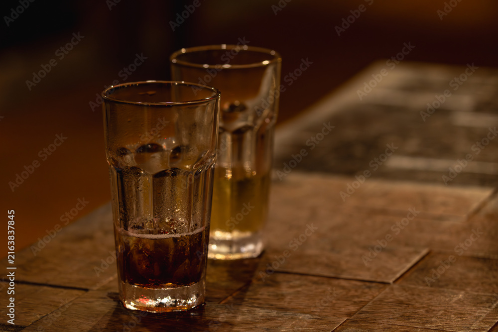 Fototapeta premium Two Drinking Glasses on a Warm Wooden Table
