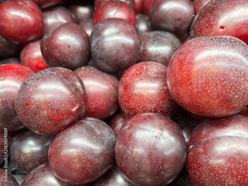 Bild auf Leinwand Full frame close-up pattern of fresh organic ripe dark red black plums displayed
