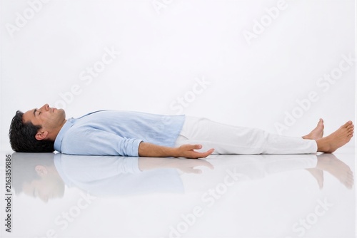 Man lying relaxed in supine position on reflective floor