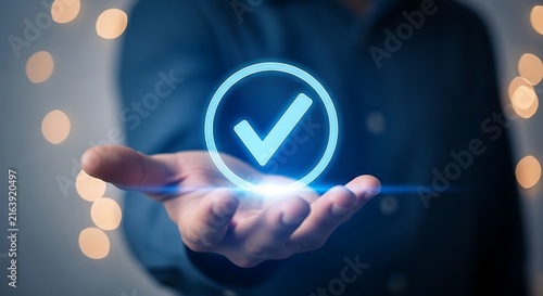 Businessman hand holding glowing digital checkmark for approval with checkmark