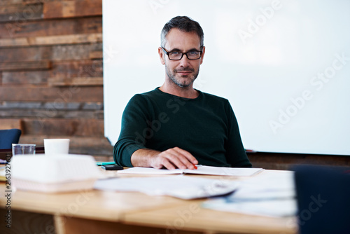Glasses, smile and portrait of business man in office for planning, campaign manager and about us. Pride, professional and branding advisor with mature employee in agency for creative and startup