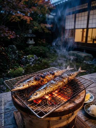 Naklejka 旅館の庭先で七輪を使って炭火で焼く美味しそうな旬の秋刀魚
