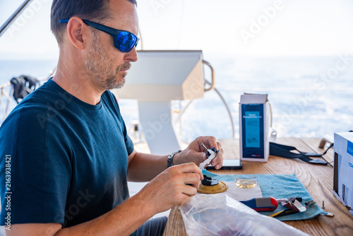 Canvastavla Man repairing yacht equipment with hand tools during a sailing trip on the Adriatic Sea