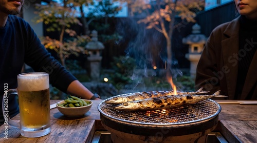 Naklejka 秋の日本庭園で七輪の網焼きサンマと枝豆をつまみにビールで乾杯する夕暮れの秋の晩酌風景
