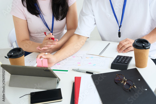 Young Japanese Man and Woman in Casual Clothes Working Together at Table