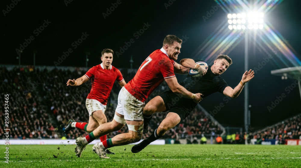 Fototapeta premium Professional Rugby Players in Intense Action During Night Match Under Stadium Lights