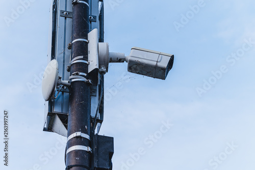 Obraz na płótnie Outdoor security camera mounted on a metal pole against a cloudy sky