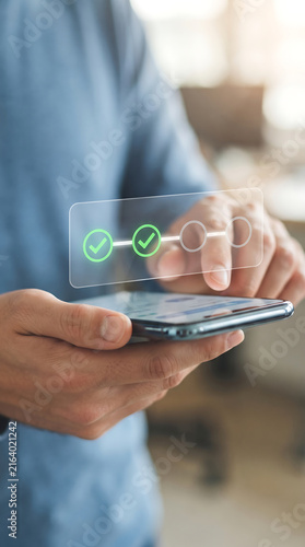 User interacting with transparent digital checklist displaying green check mark icons on smartphone screen for efficient project monitoring and task completion status verification.