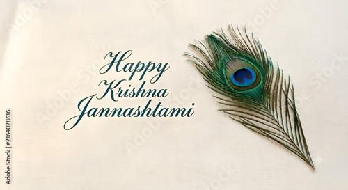 Elegant Happy Krishna Janmashtami greeting card design with a single peacock feather.