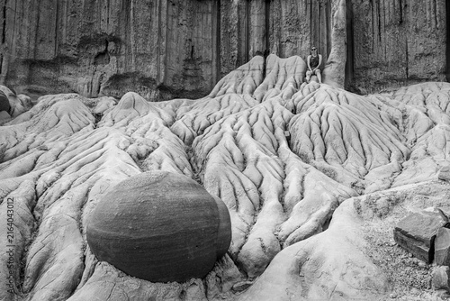 Woman sits atop surreal desert rock formations