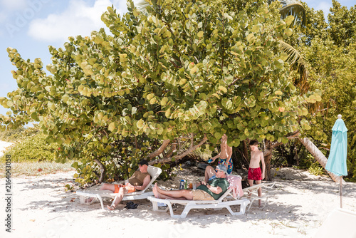 Family relaxing in the shade on a sunny beach