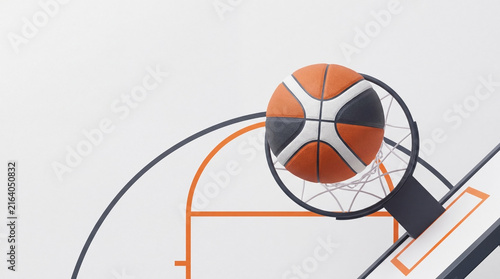 Basketball ball going through the net on a white court background