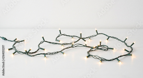 String of glowing warm white LED Christmas lights on a clean white background with copy space for festive holiday decorations