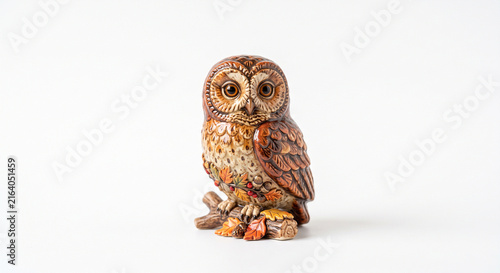 Ceramic owl figurine with detailed autumn leaves and acorns isolated on a clean white background studio shot