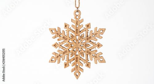 Detailed wooden snowflake ornament hanging on a string against a clean white background with ample copy space perfect for winter holiday designs