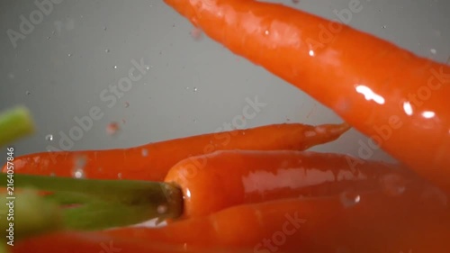 Fresh Whole Carrots Dropping into Water Creating Splashes Slow Motion Video