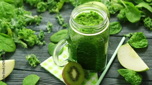 Healthy fresh green detox smoothie in glass jar with fruits and vegetables top view
