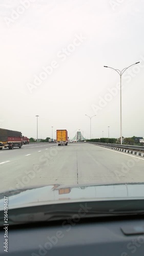 View from car driving on Delhi Meerut Expressway with trucks and highway traffic in India