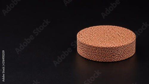 Sintered Copper Porous Filter Disc on Black Background