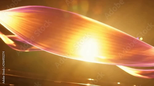Colorful light waves flow and twist through the air, illuminated by a bright sun, creating a mesmerizing visual effect against a dark background