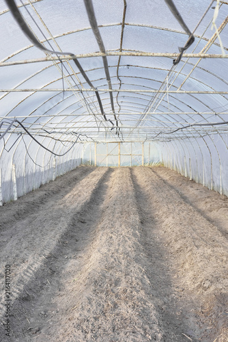 The interior of a greenhouse with soil prepared for planting.