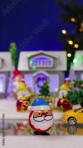 A strange Santa Claus drops into a Christmas village with letters and snowmen in the foreground