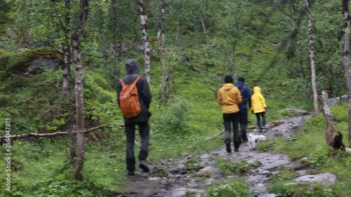 Family with children and pet dog, hiking Kilpisjarvi trail to three point border Finland Norway Sweden, the most nortern three borden in Europe