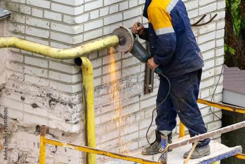 Replacing the old gas pipe with a new one. A gas service worker cuts off a gas pipe for debts.