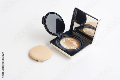 Open compact face powder with mirror and makeup sponge isolated on a clean white background, representing beauty, cosmetics, skincare, makeup application, and daily beauty routines.
